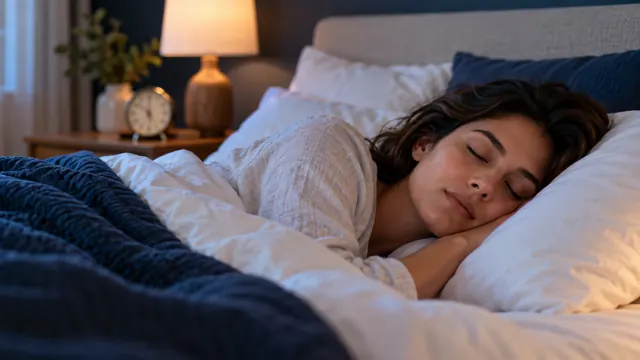 A woman asleep in bed with her head on a white pillow, seen close up